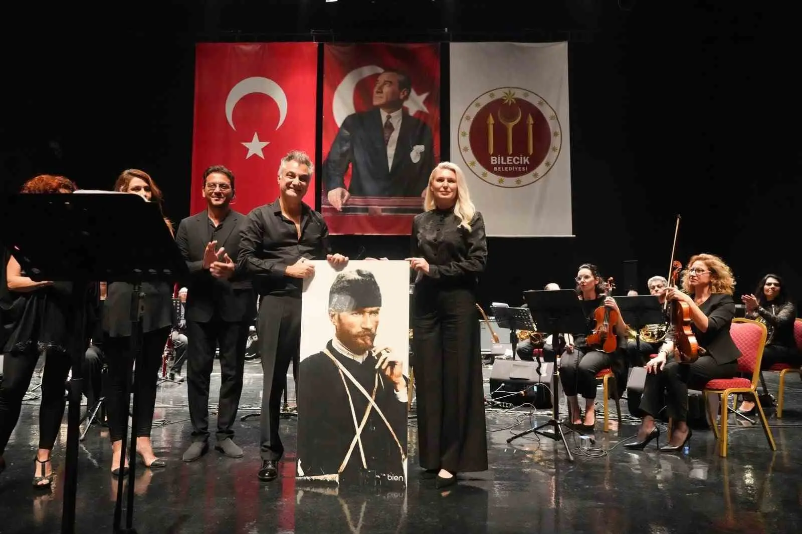 SANATÇI VE ORKESTRA ÜYELERİNE PERFORMANSLARI DOLAYISIYLA TEŞEKKÜR EDEN BAŞKAN SUBAŞI, ÇİÇEK TAKDİM EDEREK, BİLECİK SERAMİĞİNE YANSITILMIŞ ATATÜRK PORTRESİ HEDİYE ETTİ.