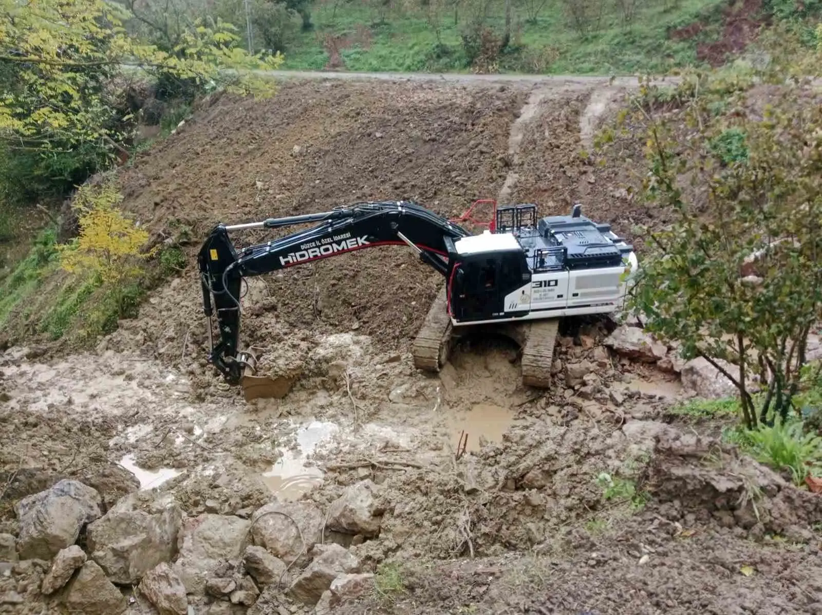 DÜZCE İL ÖZEL İDARESİ, CUMAYERİ İLÇESİNDE MEYDANA GELEN HEYELANIN ARDINDAN YOL GÜVENLİĞİNİ SAĞLAMAK İÇİN TAŞ TAHKİMATI VE DOLGU ÇALIŞMALARINI SÜRDÜRÜYOR.